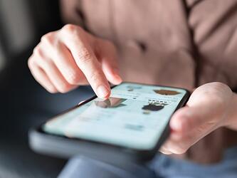 person online shopping/using smartphone to browse products on screen